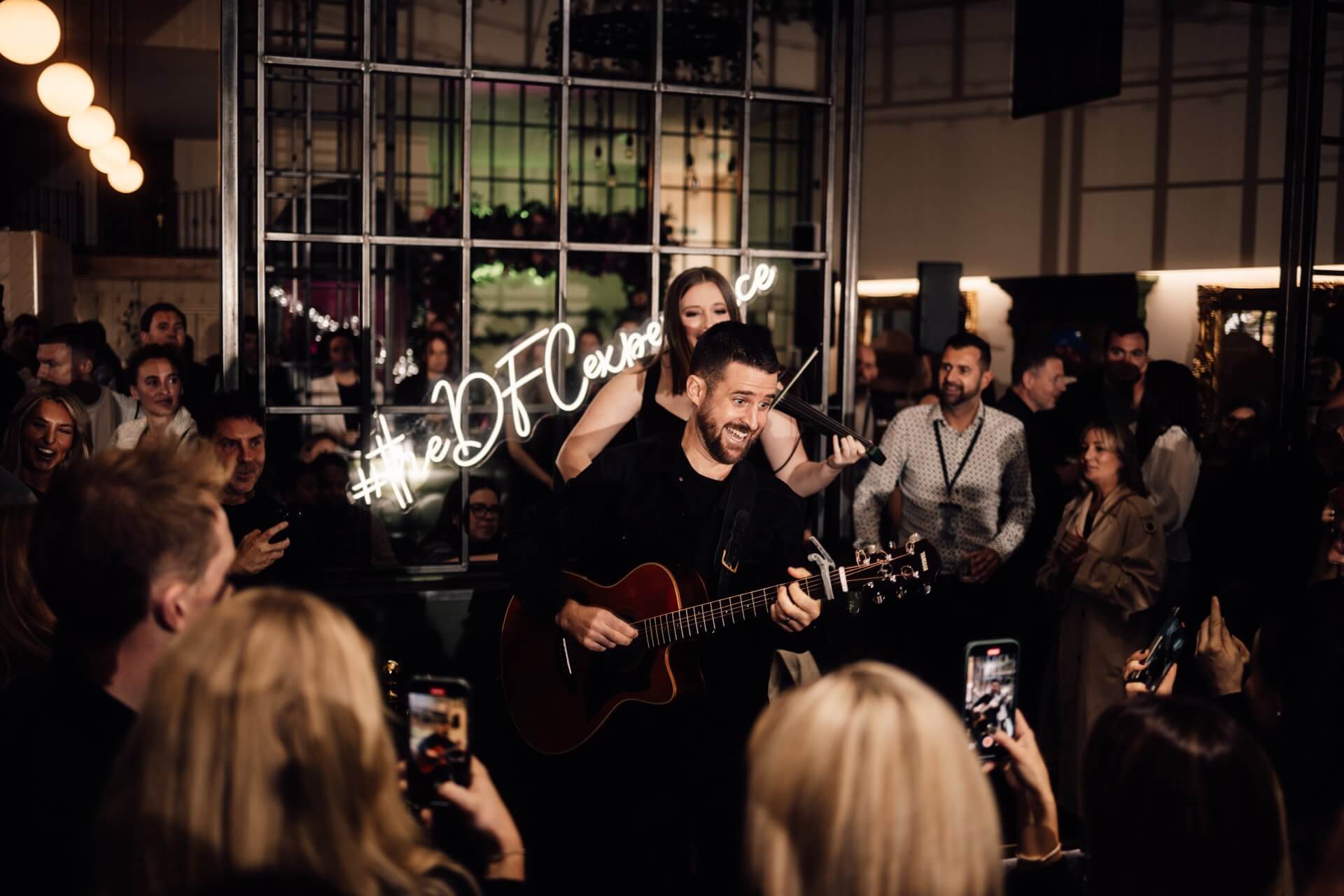 A woman singing and a man playing the guitar at a wedding